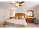 Well-lit bedroom with ceiling fan, wooden furniture, and a cozy bed at 23549 E Ottawa Pl, Aurora, CO 80016