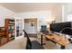 Bright home office featuring a desk, chair, and built-in bookcase with French doors at 23549 E Ottawa Pl, Aurora, CO 80016