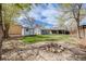 Backyard featuring a fire pit, shed, well-manicured lawn, and mature trees at 4478 S Acoma St, Englewood, CO 80110