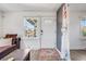 Bright living room featuring a front door with decorative glass and natural light from a window at 4478 S Acoma St, Englewood, CO 80110