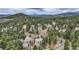 Expansive aerial view of a neighborhood nestled among lush trees and rolling hills, offering a serene setting at 31190 Cinnamonwood, Evergreen, CO 80439