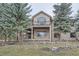 Backyard view featuring multi-level decks, mature trees, and a lush landscape at 31190 Cinnamonwood, Evergreen, CO 80439