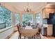 Bright dining area with large windows showcasing natural views, chandelier, and wood floors at 31190 Cinnamonwood, Evergreen, CO 80439