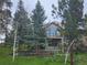 Inviting exterior view of home featuring a spacious balcony and lush, mature trees enhancing the property's natural beauty at 31190 Cinnamonwood, Evergreen, CO 80439