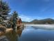 Beautiful lake view with a charming log cabin and snow dusted mountains, in a serene natural setting at 31190 Cinnamonwood, Evergreen, CO 80439