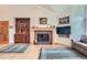 Cozy living room featuring a fireplace, built-in cabinets, hardwood floors, and comfortable seating area at 31190 Cinnamonwood, Evergreen, CO 80439