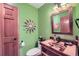 Unique powder room with green walls, decorative clock, sink and a wooden frame mirror at 31190 Cinnamonwood, Evergreen, CO 80439