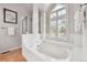 Elegant soaking tub with window view in a bright and luxurious main bathroom at 270 S Locust St, Denver, CO 80224