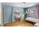 Bright bedroom with wood floors, light blue walls and two windows at 460 Lansing St, Aurora, CO 80010