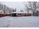 Charming brick home featuring a covered carport and a snow-covered front yard at 460 Lansing St, Aurora, CO 80010