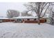 Charming brick home featuring a covered carport and a snow-covered front yard at 460 Lansing St, Aurora, CO 80010