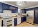 Well-lit kitchen with navy cabinets, stainless steel appliances, and tile flooring at 460 Lansing St, Aurora, CO 80010