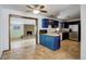 Spacious kitchen with navy cabinets, tile floors, an island, and an opening to the living room at 460 Lansing St, Aurora, CO 80010