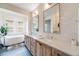 Luxurious bathroom featuring dual vanities, a soaking tub, and stylish modern finishes at 493 Pine Flower Ct, Highlands Ranch, CO 80126