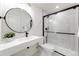 Modern bathroom features sleek vanity, round mirror, and tiled shower with black framed glass door at 493 Pine Flower Ct, Highlands Ranch, CO 80126