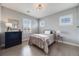 Well-lit bedroom features a vintage bed, modern light fixture, and shuttered windows at 493 Pine Flower Ct, Highlands Ranch, CO 80126