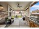 Inviting covered patio with stone features, grill, ceiling fan, and outdoor seating at 493 Pine Flower Ct, Highlands Ranch, CO 80126