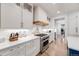 Bright kitchen features white cabinets, stainless steel appliances, and a stylish backsplash at 493 Pine Flower Ct, Highlands Ranch, CO 80126