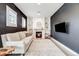 Inviting living room featuring a cozy fireplace, stylish decor, and large windows at 493 Pine Flower Ct, Highlands Ranch, CO 80126