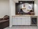 Finished basement featuring a sleek wet bar with custom cabinetry and beverage refrigerator at 493 Pine Flower Ct, Highlands Ranch, CO 80126