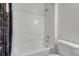 Clean white tiled bathroom with a shower-tub combo and a toilet, providing a functional space at 14333 E 1St Dr # 307, Aurora, CO 80011