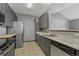 Functional kitchen features modern stainless steel appliances, tile flooring, and gray cabinetry at 14333 E 1St Dr # 307, Aurora, CO 80011