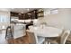 Bright dining area featuring a modern round table and dark cabinetry in the kitchen at 12740 Tamarac St, Thornton, CO 80602