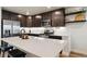 Modern kitchen with stainless steel appliances, a large island, and dark cabinets at 12740 Tamarac St, Thornton, CO 80602