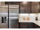 Stainless steel refrigerator and dark cabinetry provide modern convenience at 12740 Tamarac St, Thornton, CO 80602