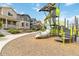 Community playground with a slide and climbing structure surrounded by mulch and townhomes at 12740 Tamarac St, Thornton, CO 80602