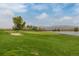 Well-maintained golf course with a sand trap next to a green with a lakeside view and blue skies at 2290 S Braun Way, Lakewood, CO 80228