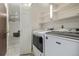 This well-equipped laundry room features a new washer and dryer, storage shelves, and a door to the outside at 2290 S Braun Way, Lakewood, CO 80228