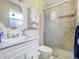 Bathroom with a white vanity, toilet, and tiled shower with sliding glass door at 7936 Eaton St, Arvada, CO 80003
