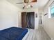 View of bedroom leading to the bathroom with ceiling fan and hardwood floors at 7936 Eaton St, Arvada, CO 80003