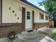 A well maintained front entrance and porch featuring a brick facade, white painted siding, and concrete steps at 7936 Eaton St, Arvada, CO 80003