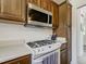 Close up of stainless steel microwave, gas range, and oak cabinets in the kitchen at 7936 Eaton St, Arvada, CO 80003