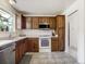 Traditional kitchen with warm wood cabinetry, white appliances, tile floors and laminate countertops at 7936 Eaton St, Arvada, CO 80003