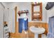 Charming bathroom with pedestal sink, vintage medicine cabinet, and wood paneling at 1918 Virginia St, Idaho Springs, CO 80452