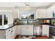 Bright kitchen with stainless steel appliances, white cabinets, and a window over the sink at 5207 S Jericho Way, Centennial, CO 80015