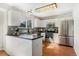 Well-lit kitchen with modern white cabinetry, a stainless steel refrigerator, hardwood floors, and ample counter space at 5207 S Jericho Way, Centennial, CO 80015