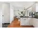 Open-concept kitchen with a breakfast bar, modern white cabinets, stainless steel appliances, and hardwood floors at 5207 S Jericho Way, Centennial, CO 80015