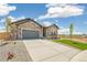 Charming stone-accented home with a gray garage door, complemented by a well-manicured lawn and landscaping at 6384 E 154Th Pl, Thornton, CO 80602