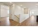 Bright hallway with wood-style floors leading to a stairwell and multiple rooms at 6384 E 154Th Pl, Thornton, CO 80602