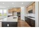 Bright modern kitchen with stainless appliances, large island and wood-style floors at 6384 E 154Th Pl, Thornton, CO 80602