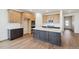 Well-equipped kitchen features wood cabinets, a dark island with white countertop, and stainless steel appliances at 6384 E 154Th Pl, Thornton, CO 80602