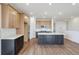 Modern kitchen featuring wood cabinets, gray island with white countertop, and stainless steel appliances for cooking at 6384 E 154Th Pl, Thornton, CO 80602
