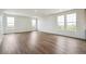 Sunlit living room with sleek wood floors and multiple windows, providing a bright and airy atmosphere at 6384 E 154Th Pl, Thornton, CO 80602
