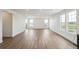 Bright living room with sleek wood floors, complemented by multiple windows offering natural light at 6384 E 154Th Pl, Thornton, CO 80602