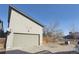 Attached garage with a gray door and partial view of the home's siding at 1622 W 67Th Ave, Denver, CO 80221