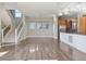 Spacious open-concept living area with hardwood floors, modern staircase, and an adjacent kitchen at 1622 W 67Th Ave, Denver, CO 80221